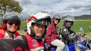 Helmeted riders by green fields on a Nha Trang to Da Lat Easy Rider tour