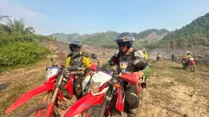 Helmeted motorbike riders on a dirt track during a Vietnam motorcycle adventure