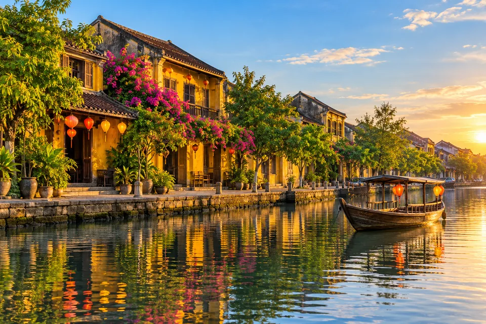 Yellow riverside houses and lanterns in Hoi An with a traditional wooden boat